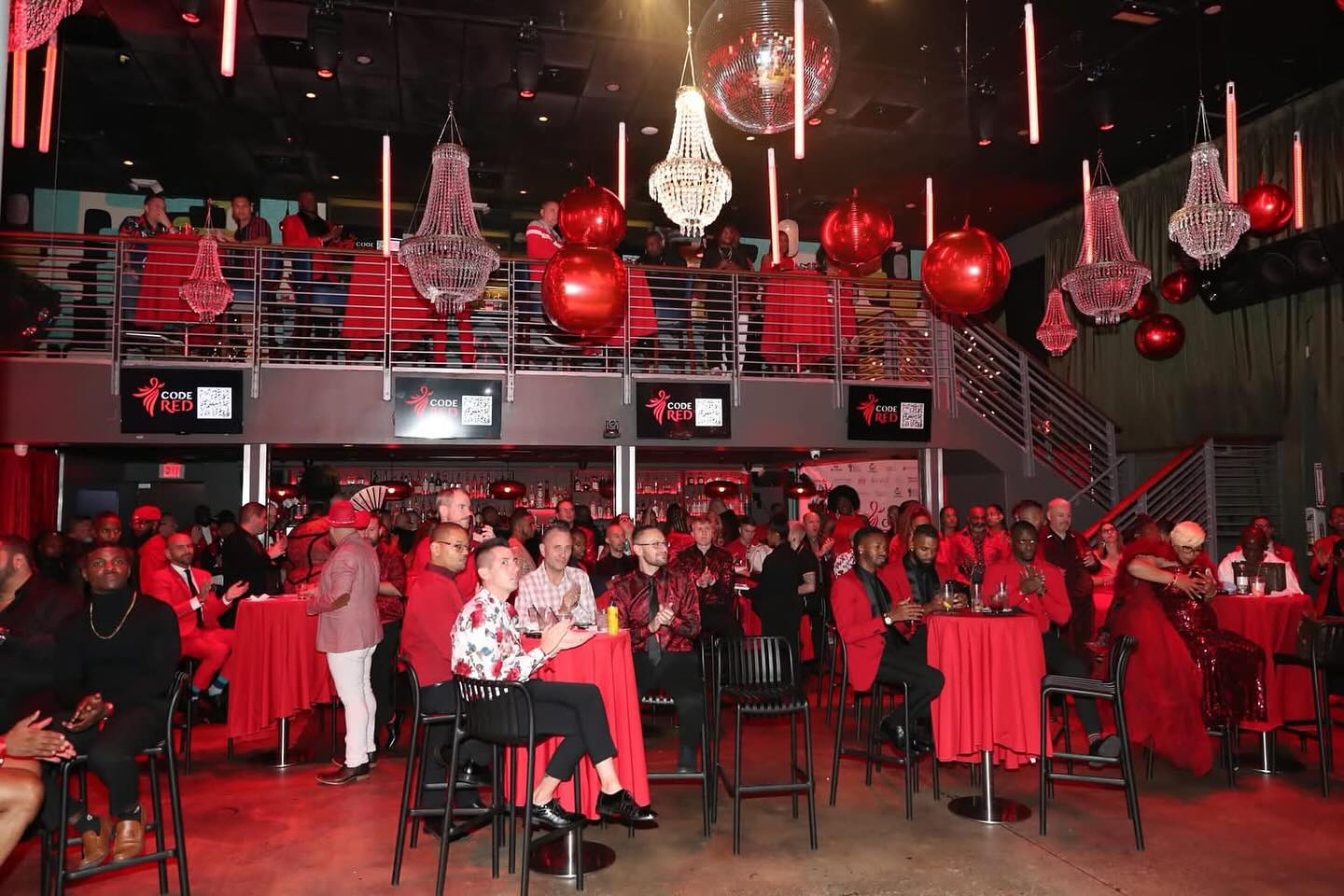 A packed community audience wearing red at The Rapha Center's Code Red event